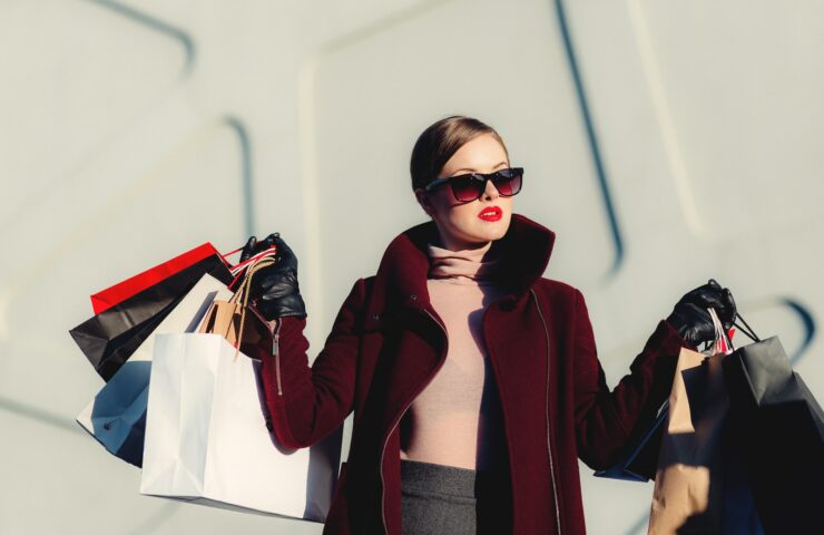 photo of woman holding white and black paper bags